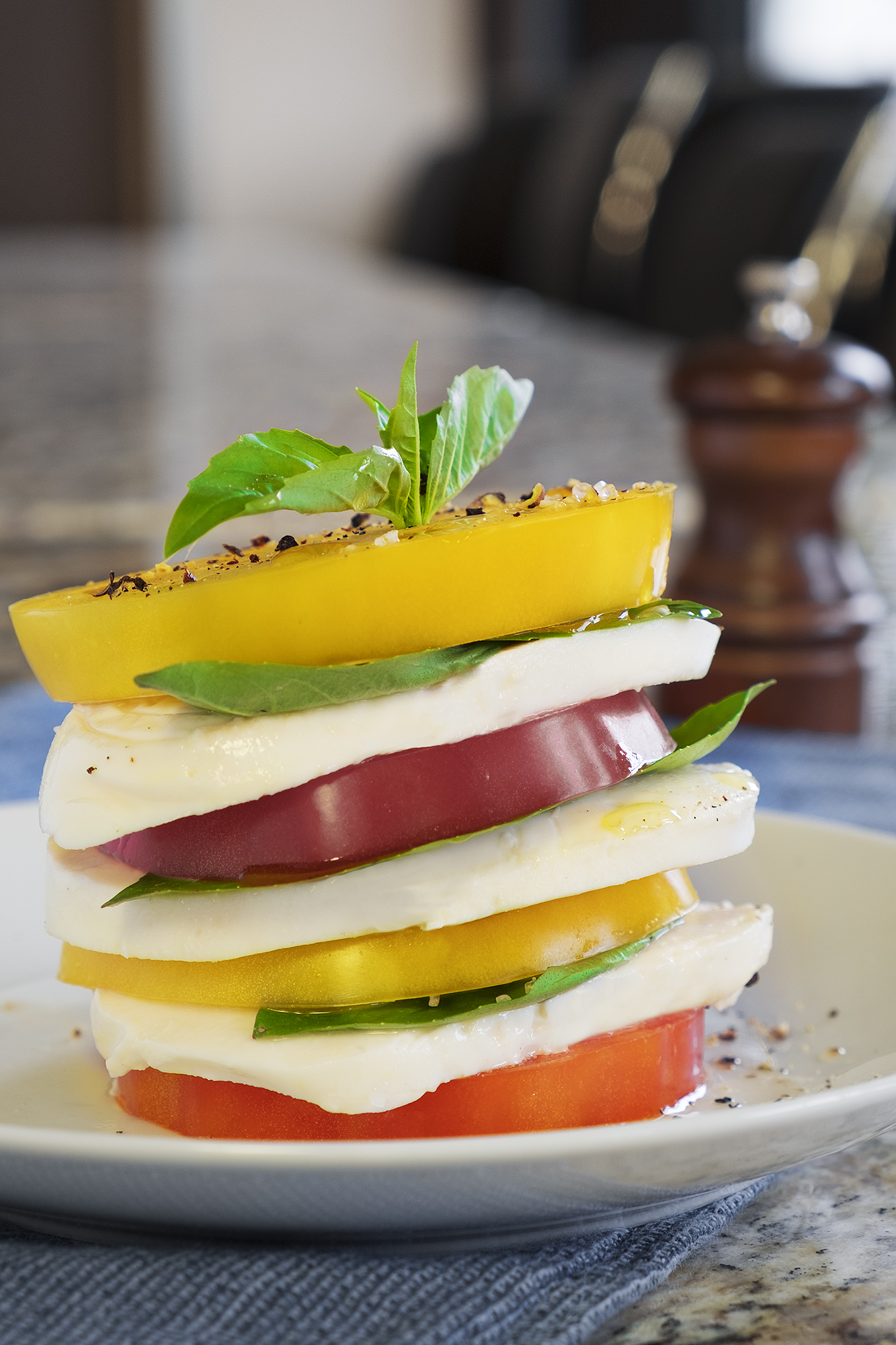 A tower of sliced heirloom tomatoes that is prepared to accomplish the tall task of satisfying your expectations.