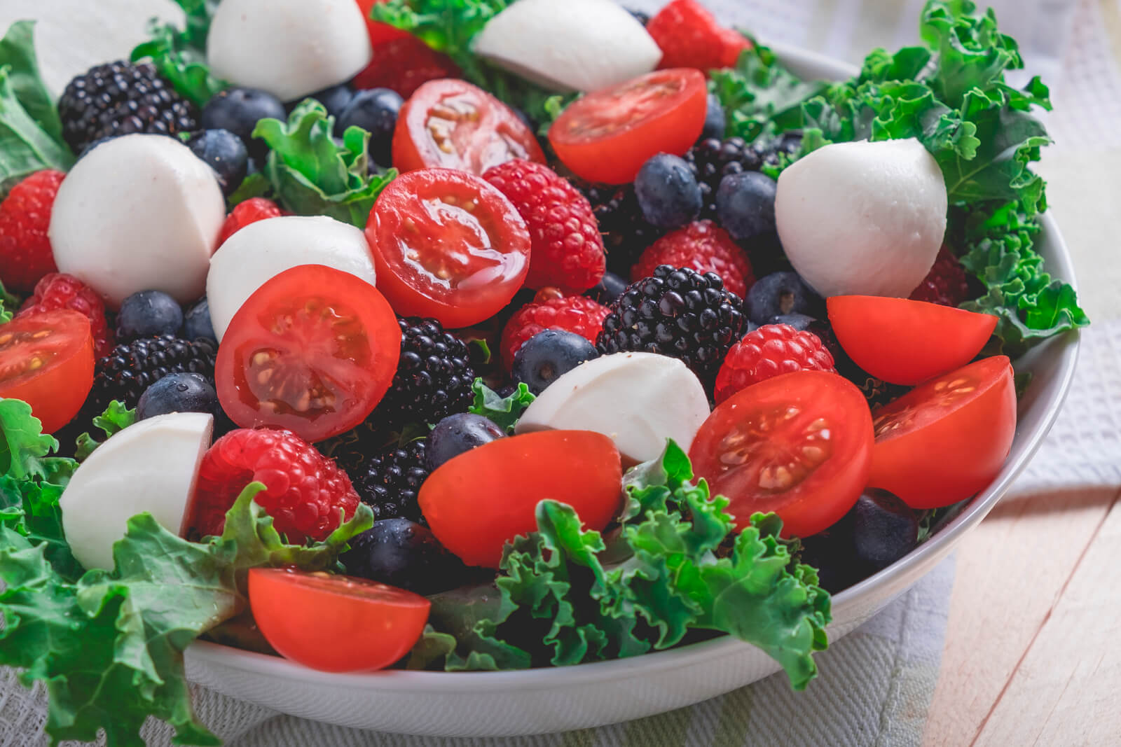 This delicious cherry tomato & berry salad is the taste of summer! Try it once and you'll see why it's become a go-to dish for all occasions!
