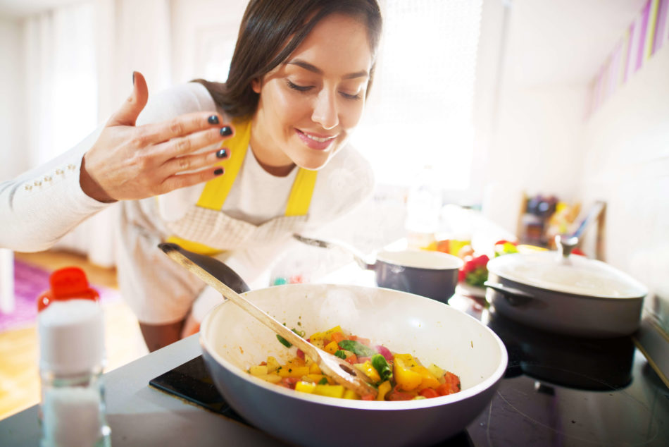 Woman Smelling Food Cooking in Dish